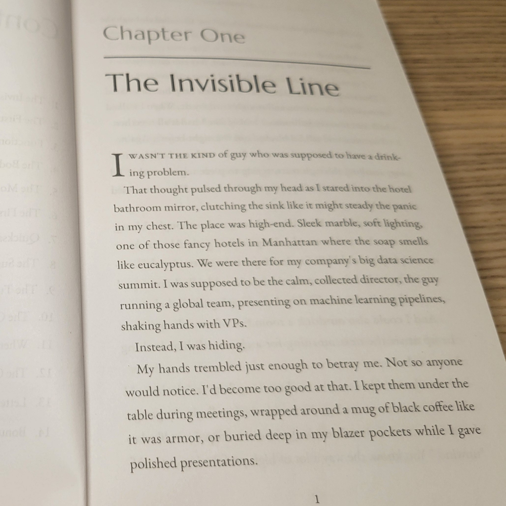 Open book with text beginning 'The Invisible Line' on a wooden surface