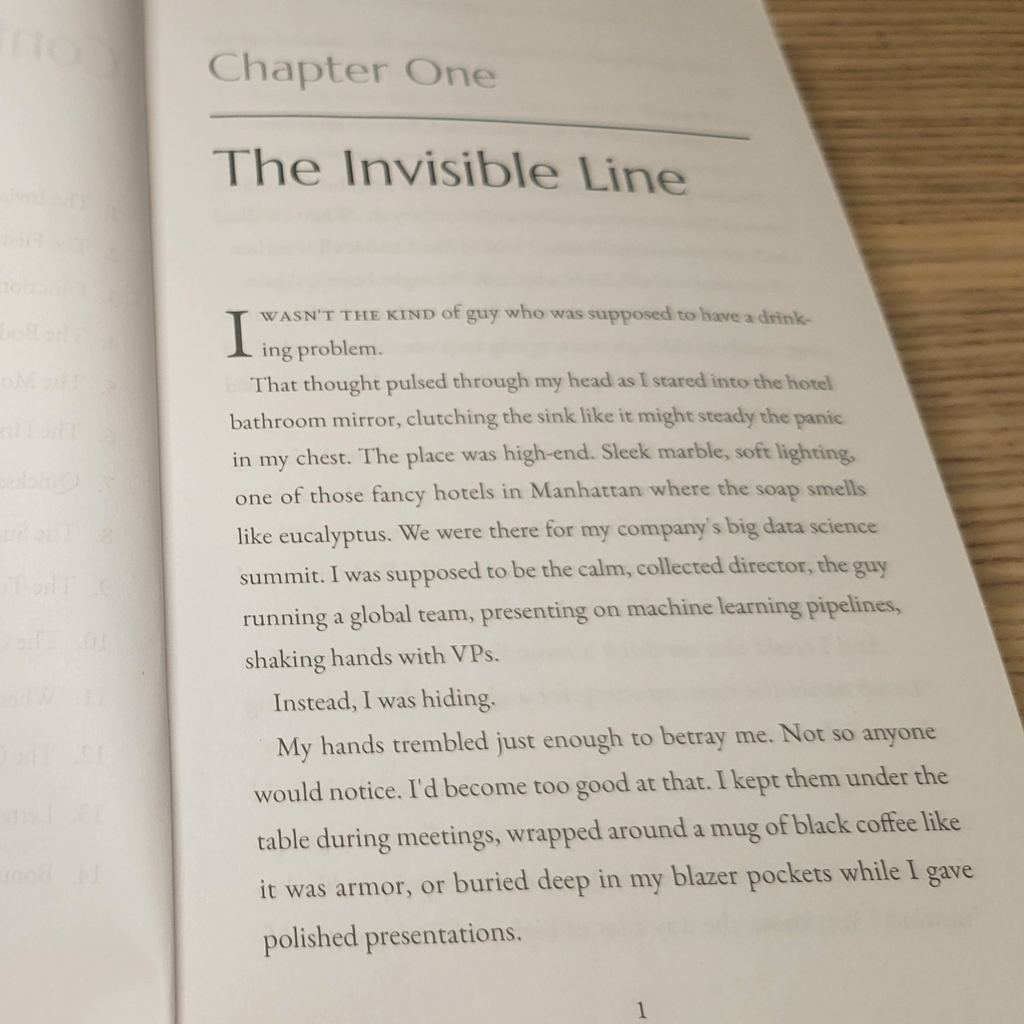 Open book with text beginning 'The Invisible Line' on a wooden surface