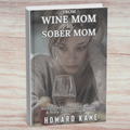 Book cover titled 'From Wine Mom to Sober Mom' by Howard Kane on a wooden surface.